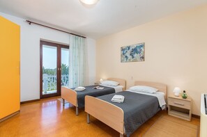 A hotel room with two beds, a large window with curtains, a painting on the wall, and a small bedside table with a lamp. - House Max - charming holiday house with private pool, near the beach (Mugeba)