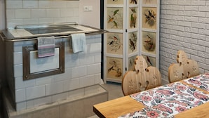 A modern kitchen with a built-in stove, a hanging light, and a brick wall. - Cozy 3-Bedroom Apartment for 5-6 guests with mountain views, with free parking (Zakopane)