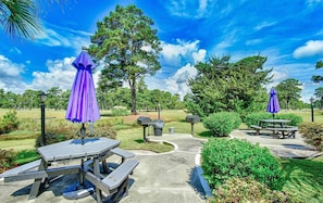 A park with picnic tables, purple umbrellas, and a well-maintained lawn. - Immaculate 2BR, 1st Floor Condo in Myrtlewood Villas! (Myrtle Beach)