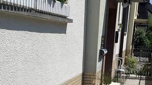 A courtyard with a bike rack, a planter with flowers, and a potted plant. - 5 Minuten von Koblenz Uni Entfernt Ferienwohnung (Koblenz)