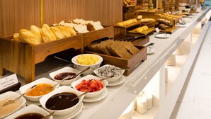 A buffet with various food items including bread, pastries, and fruits. - S Lux Apartment Virgo Nha Trang (Nha Trang)