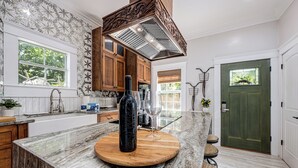 A kitchen with a marble countertop, wooden cabinets, a built-in stove, and a green door. - Oak & Ocean * Pet Friendly, Boat Launch, Firepit, Hot Tub, Grill (Santa Rosa Beach)