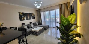 A modern living room with a sofa set, a dining table, and a large plant. - Breathtaking sea view – quiet *Susi's The View* (Hurghada 1,)