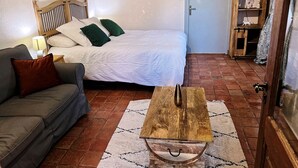A bedroom with a bed, a wooden coffee table, a sofa, and a small cabinet. - My little paradise / private indoor pool (Lournand)