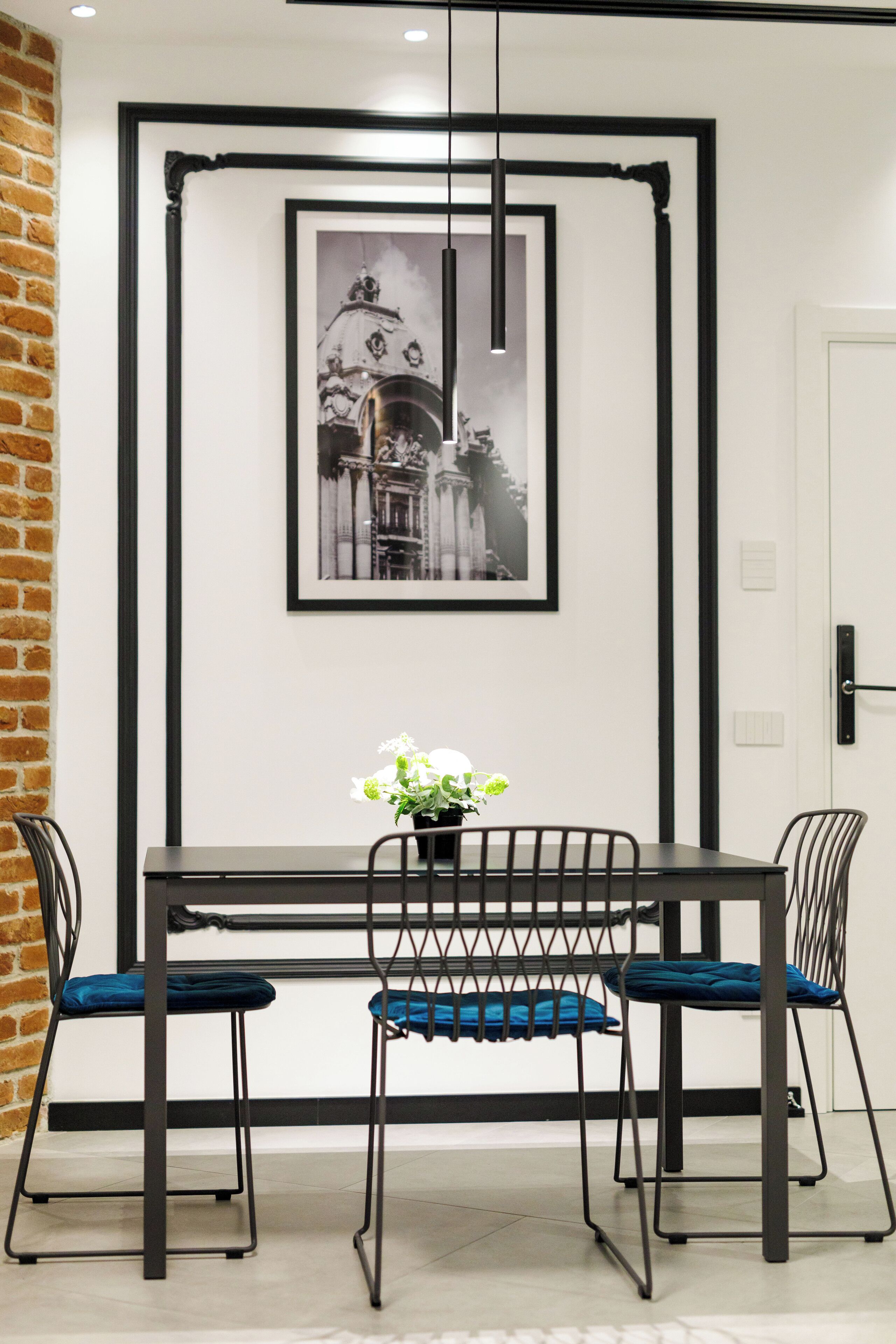 Un comedor con una mesa, sillas y un cuadro en la pared.