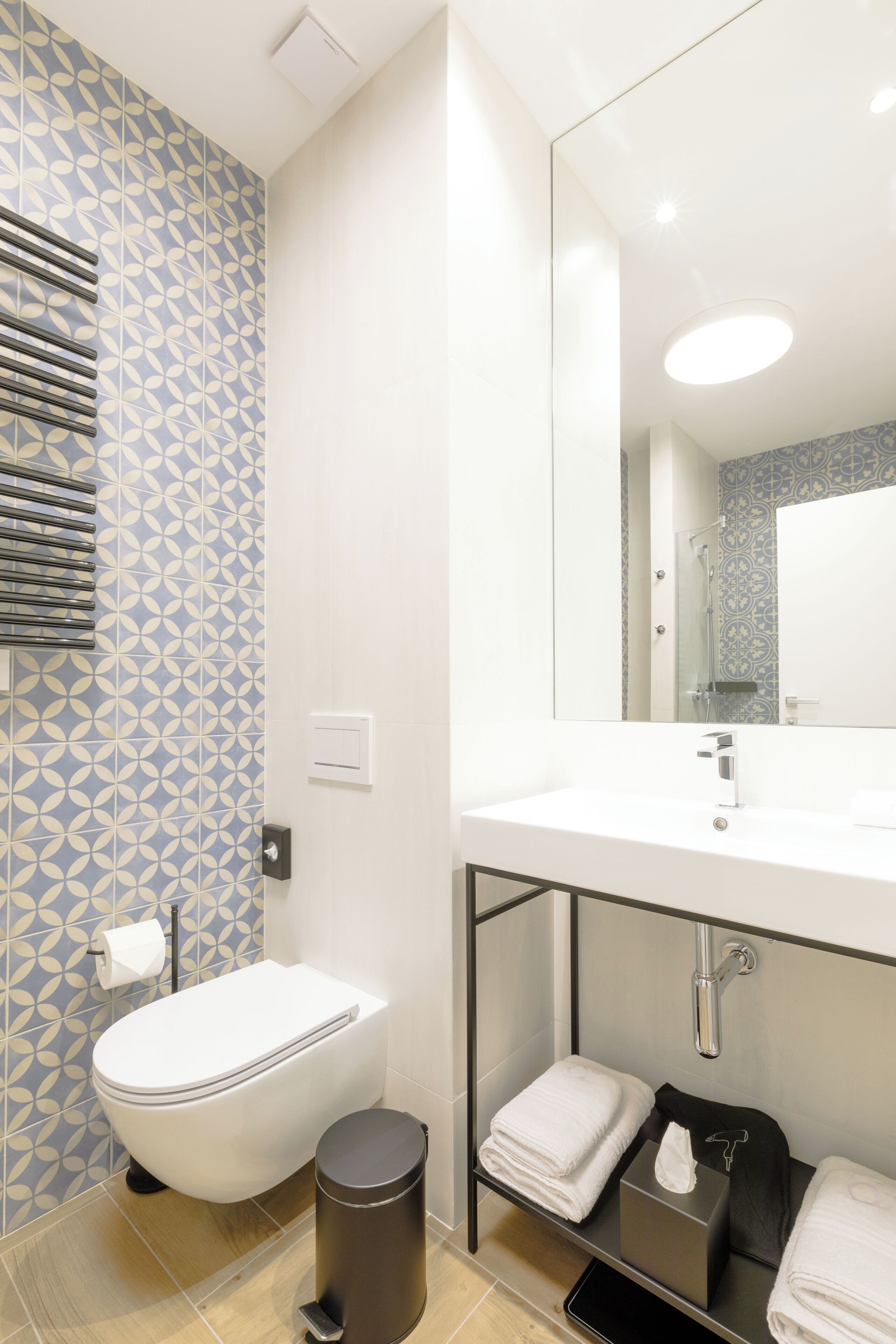 A modern bathroom with a toilet, sink, and mirror.