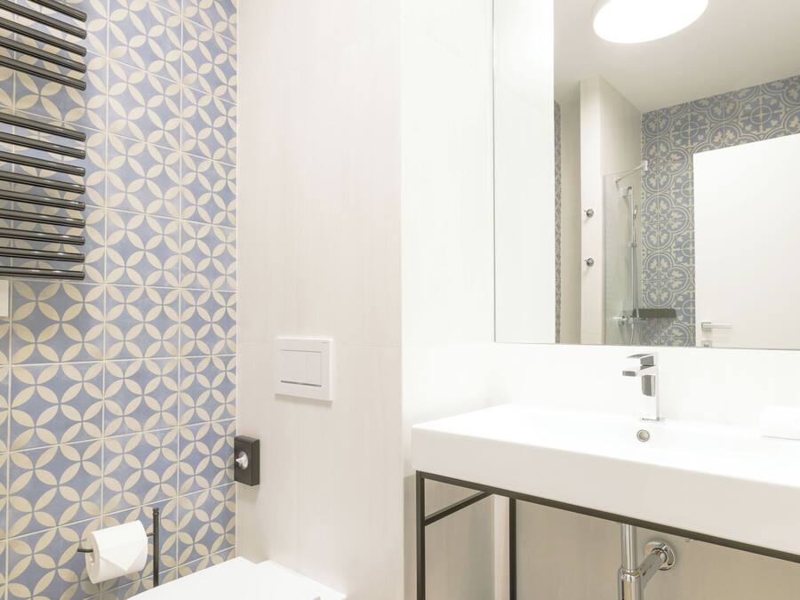 A modern bathroom with a toilet, sink, and mirror.
