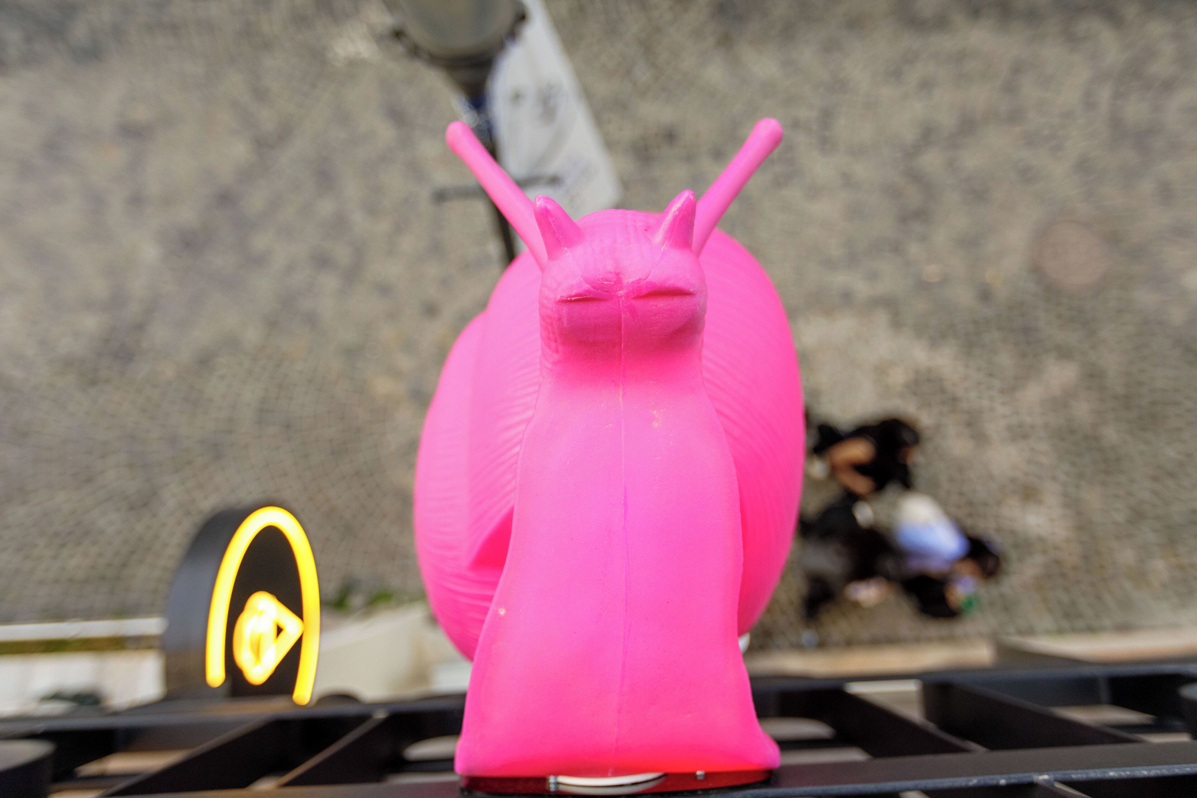 Una escultura rosa con antenas sobre una superficie metálica.