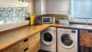 A compact kitchen with a washing machine, a toaster, and a window with a fish pattern. - 2 bedroom accommodation in Shrawley, near Worcester (Shrawley, near Worcester)