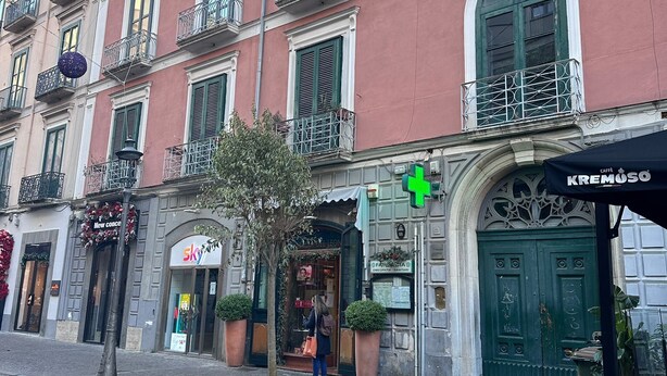 A multi-story building with a red facade, green shutters, and balconies. - Home To Salerno B&B (Salerno)