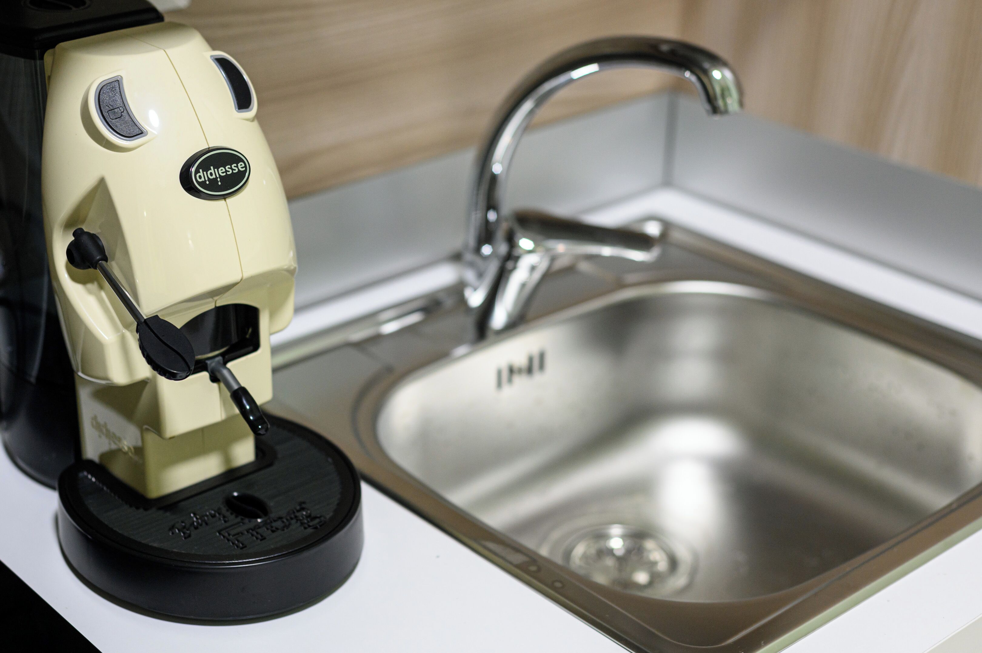 A coffee machine and a stainless steel sink.