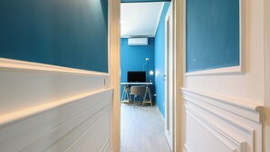 A hallway with blue walls, white trim, and a desk with a chair. - Via Nuova Marina 121 - Appartamento 1 (Naples)