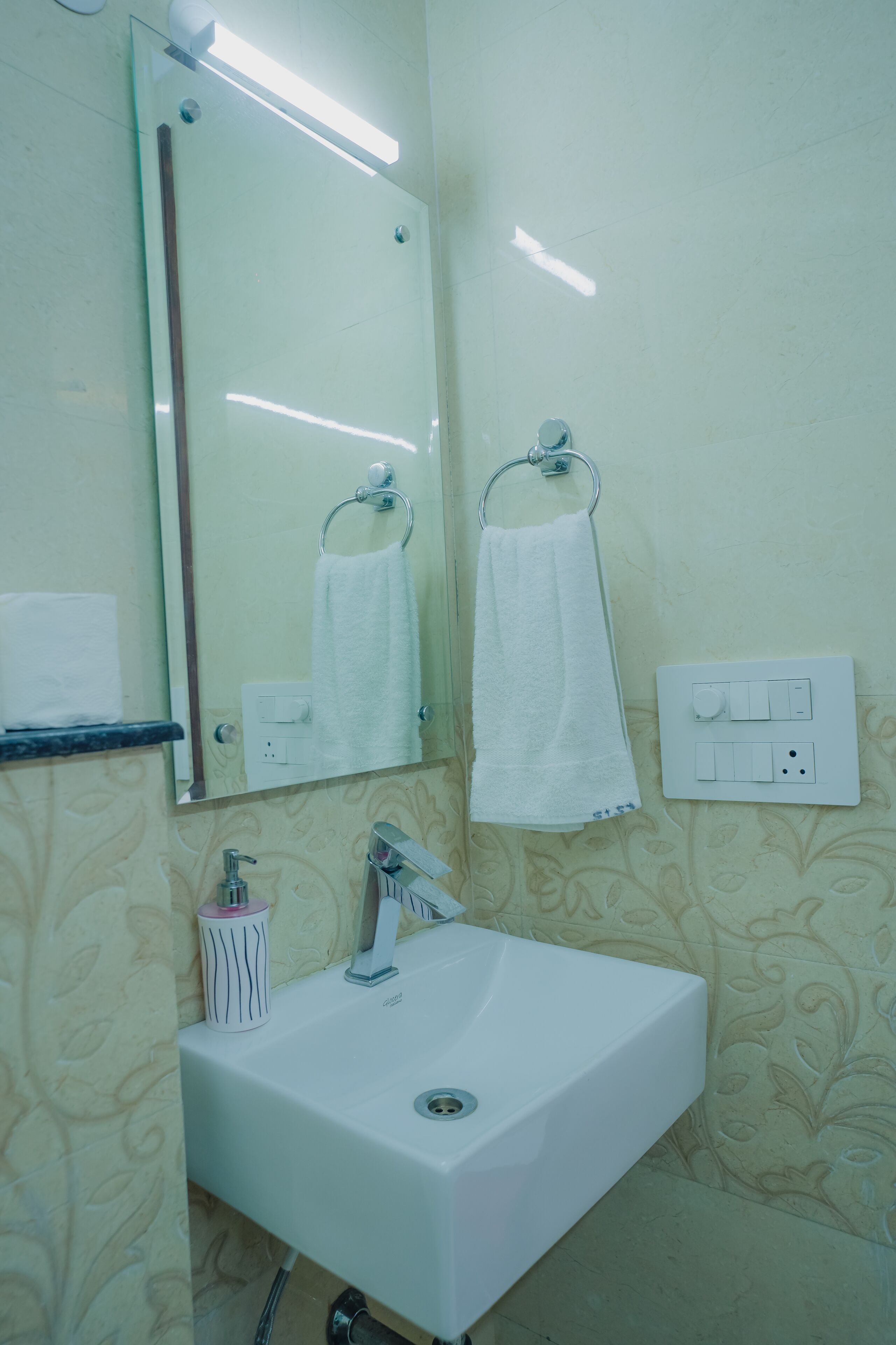 A bathroom with a white sink, a mirror, and a towel rack.