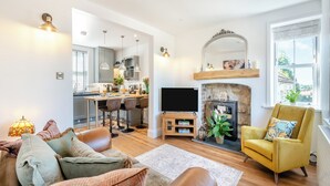 A modern living room with a sofa, a yellow armchair, a fireplace, and a television. - 3 bedroom accommodation in Pickering (Pickering)