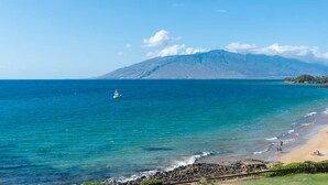A coastal view with a beach, ocean, and a mountain in the background. - Royal Mauian 503-Oceanfront with AC (Kihei)
