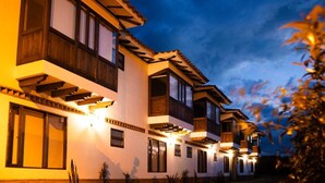A multi-story hotel with balconies and exterior lighting. - Villa Santa Ana Premium (Villa de Leyva)