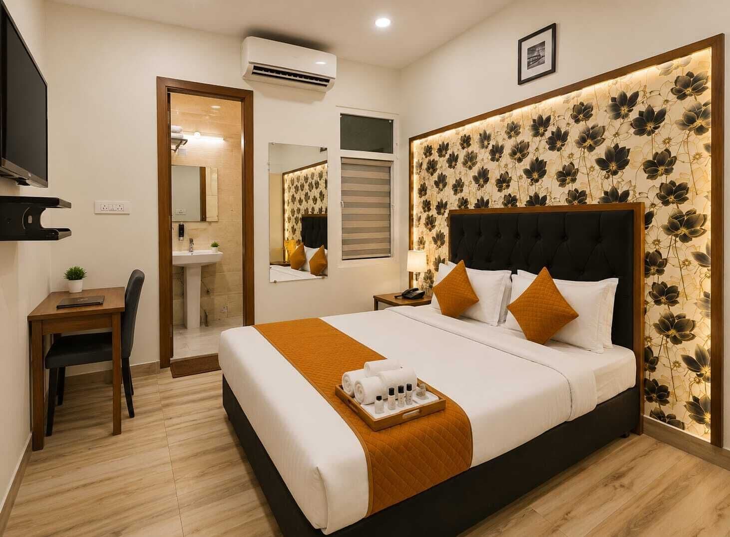 Habitación de hotel con una cama grande, una mesita de noche, un escritorio y un equipo de aire acondicionado.