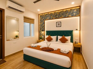 A hotel room with a large bed, a bedside table with a lamp, a wall-mounted air conditioner, and a window with blinds. - Hotel Silver Saffron Peeragarhi (New Delhi)