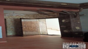 A hallway with a wooden door, a wall-mounted light fixture, and a patterned wall. - Appartement a Louer au Nord du Maroc Fnideq (Fnideq)