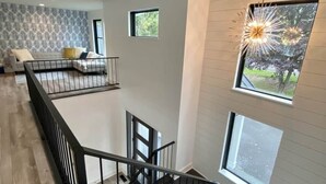 A modern interior with a staircase, a balcony, and a dining area. - BRAND NEW 7 BR / 5 BA luxury home ON Keuka Lake just outside of Penn Yan! (Penn Yan)