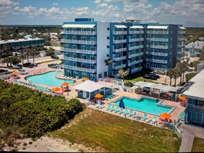 Relax by the central pool surrounded by lush greenery and sun loungers.