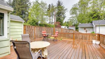Guests can enjoy an outdoor space with a round table and two chairs, surrounded by a fence and adjacent to the building.