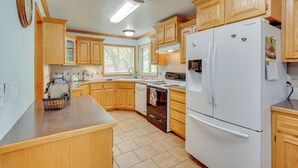 Une cuisine avec des meubles de rangement en bois, un réfrigérateur blanc, une cuisinière et un four à micro-ondes.