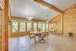A spacious dining area with a wooden table and chairs, large windows, and ceiling fans. - Peaceful Garden City Getaway w/ Grill & Fire Pit (Garden City)
