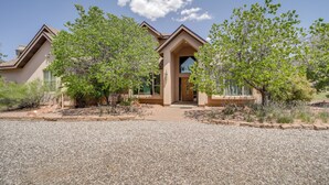 A modern house with a gravel driveway, surrounded by trees and shrubs. - Red Rock State Park Views: Sedona Home w/ Fire Pit (Sedona)