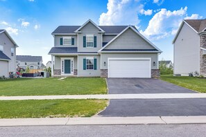 A two-story residential house with a garage, a front lawn, and a driveway.