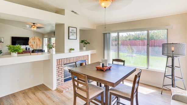 A spacious kitchen with a dining area, a fireplace, and large windows.