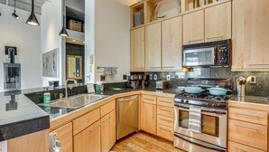A modern kitchen with wooden cabinets, stainless steel appliances, and a granite countertop. - Near Trail: Dtwn Eagle Ranch Condo w/ Balcony (Eagle)