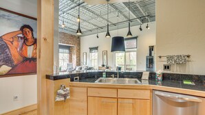 A modern kitchen with wooden cabinets, a stainless steel dishwasher, and pendant lighting. - Near Trail: Dtwn Eagle Ranch Condo w/ Balcony (Eagle)