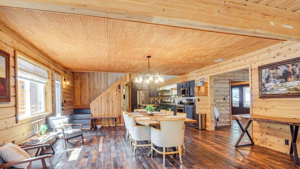 Un interior de madera con comedor, cocina y asientos junto a la ventana.