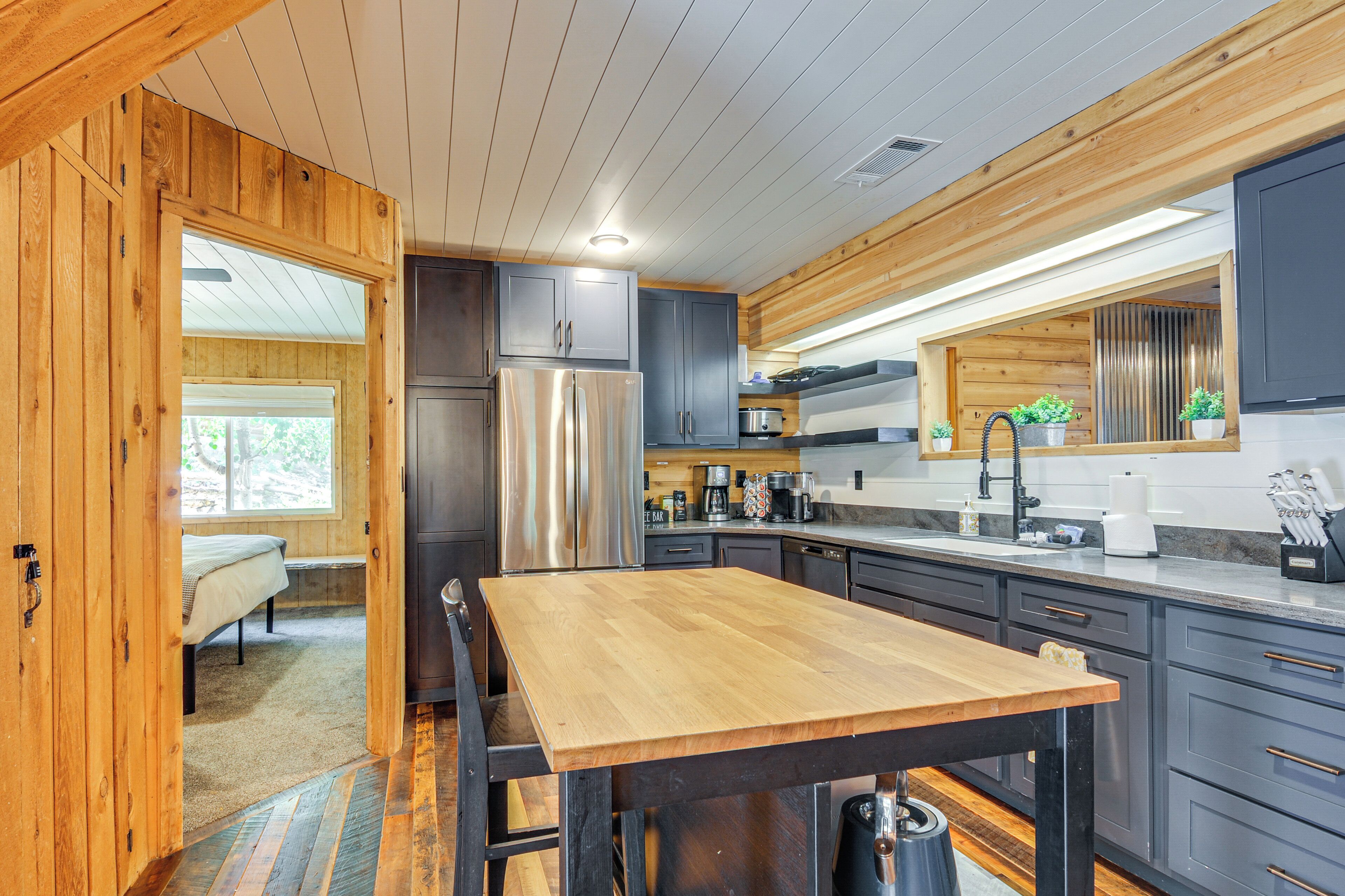 A modern kitchen with wooden accents, stainless steel appliances, and a central island.