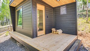 Una cabaña con terraza de madera, puerta de cristal y un cartel con normas.