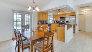 Une cuisine spacieuse avec des meubles en bois, un grand îlot central et des appareils électroménagers modernes.