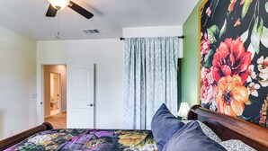 A bedroom with a bed, a ceiling fan, a door, and a floral wall mural. - 16 Mi to Lake Tahoe: Carson City Townhome (Carson City)