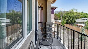 A balcony with a stone pillar, a metal chair, and a small table. - 16 Mi to Lake Tahoe: Carson City Townhome (Carson City)