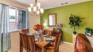 A dining room with a wooden table set for four, surrounded by chairs. A chandelier hangs from the ceiling, and a potted plant is on the side table. - 16 Mi to Lake Tahoe: Carson City Townhome (Carson City)