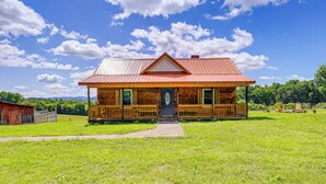 A wooden cabin with a red roof, a front porch, and a visible front door. - Deck & Scenic View: Historic Cabin in Piney Creek! (Piney Creek)