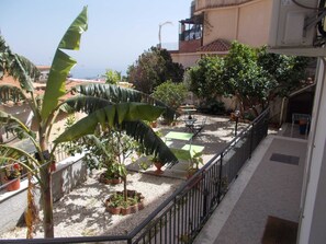 Un balcon agrémenté de plantes en pot, une table et des chaises.