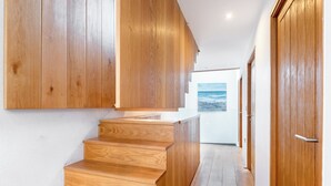 A wooden staircase leading to a door with a view of the ocean. - Architecturally designed fishing warehouse conversion (Newlyn)