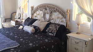 A bedroom with a bed, nightstands, a lamp, a painting, and curtains. - Marbella Coast Hotel (Marbella)