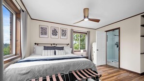 A bedroom with a bed, a ceiling fan, a window, and a door leading to a bathroom. - Rolling Hills/Hot Tub/Firepit/Mins to ACE+NRG (Oak Hill)
