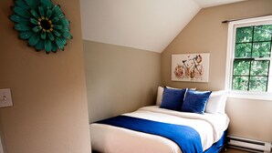 Un dormitorio con cama, ventana y decoración en la pared.