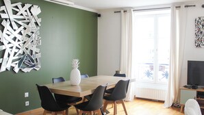 A dining area with a wooden table, black chairs, and a white pineapple centerpiece.