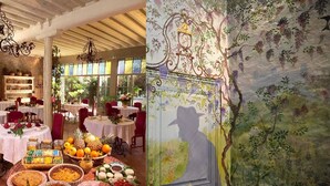 Een eetruimte met ronde tafels, een buffet met fruit en gebak, en een muurschildering met een boom en een figuur.