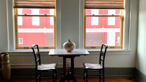 A room with two windows, a table, and two chairs. - Private Downtown Apartment in Red Cloud, in the heart of Willa Cather country (Red Cloud)