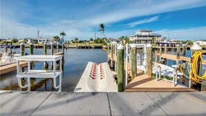 A marina with boats docked, a white bench, and a clear sky. - Paradise on the water w/ a pool & great fishing! (Saint James City)